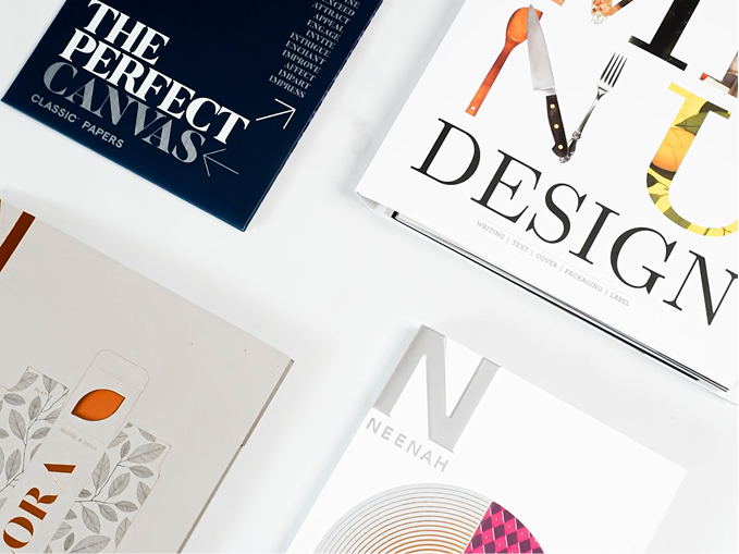 Overhead view of design process materials and printed matter on a studio desk
