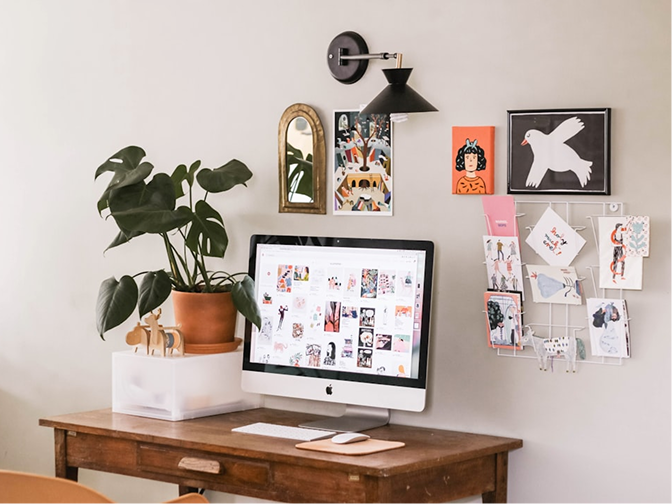 Studio workspace with a desk, monitor, and pinned reference material